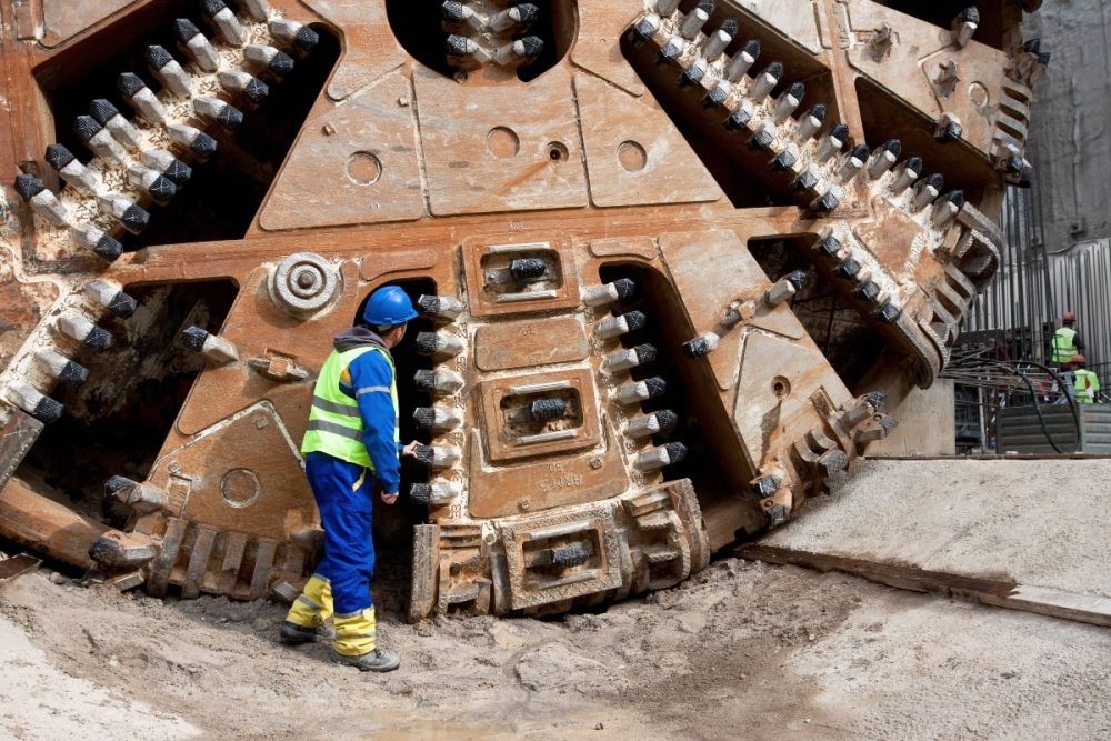 A worker inspecting the cutter head of tunnel boring machine.